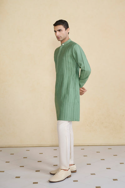 Make a subtle statement with Daeven. A classic kurta crafted in a soothing hue & elevated in threadwork & zari. Comes with pintuck details & pockets on either side.
